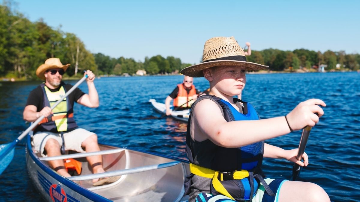 Familj paddlar kanot på sjö i Olofström, Blekinge – sommaraktivitet för barn och vuxna