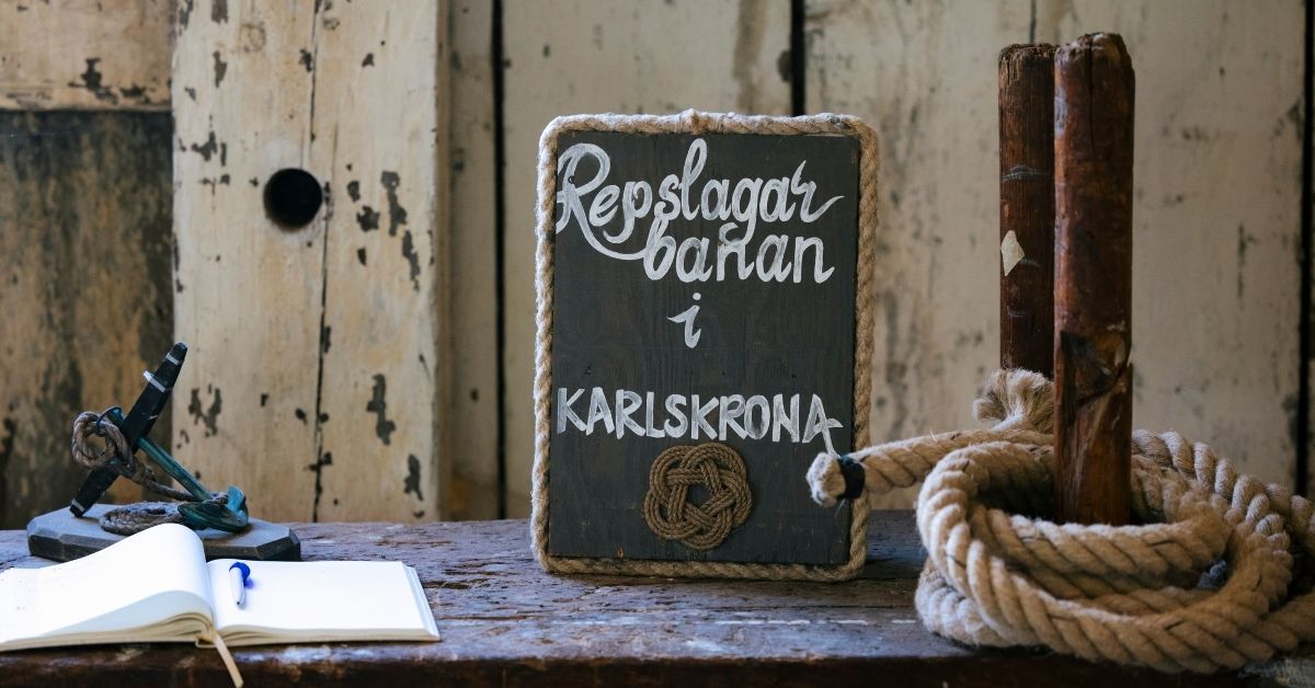 Skylt med texten Repslagarbanan i Karlskrona, del av världsarvet Örlogsstaden Karlskrona med maritim historia och sjöfartstradition.