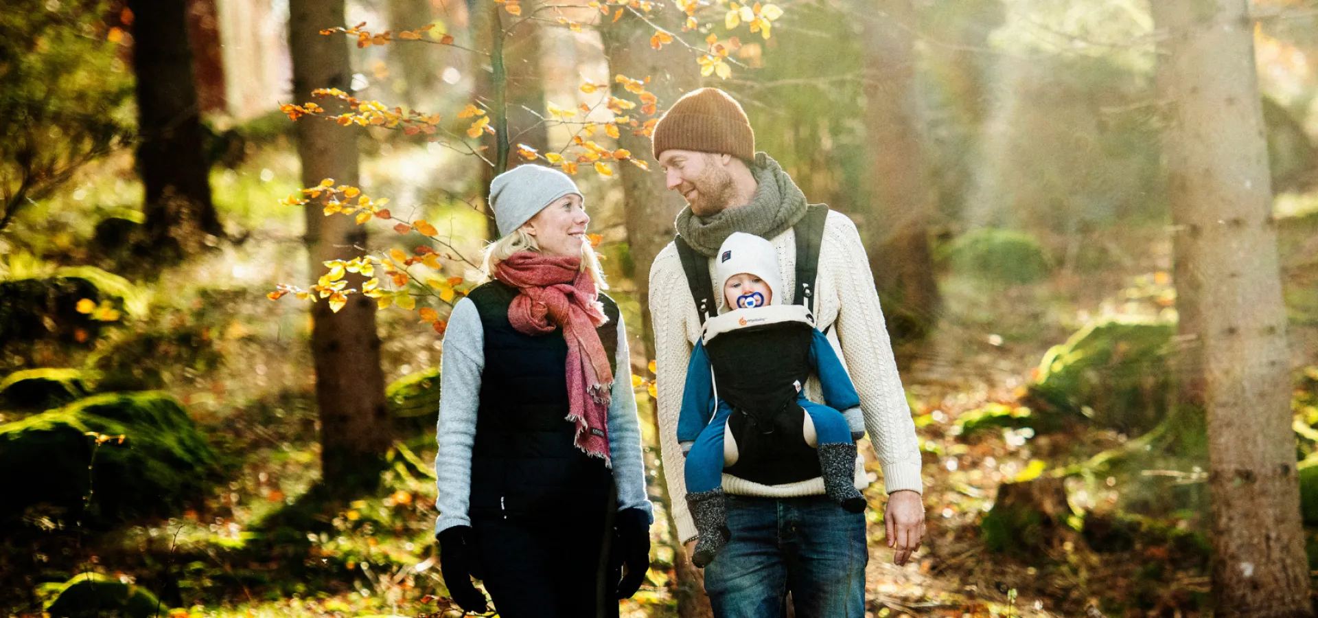 Familj som vandrar genom skog i Blekinge. Höstfärger.