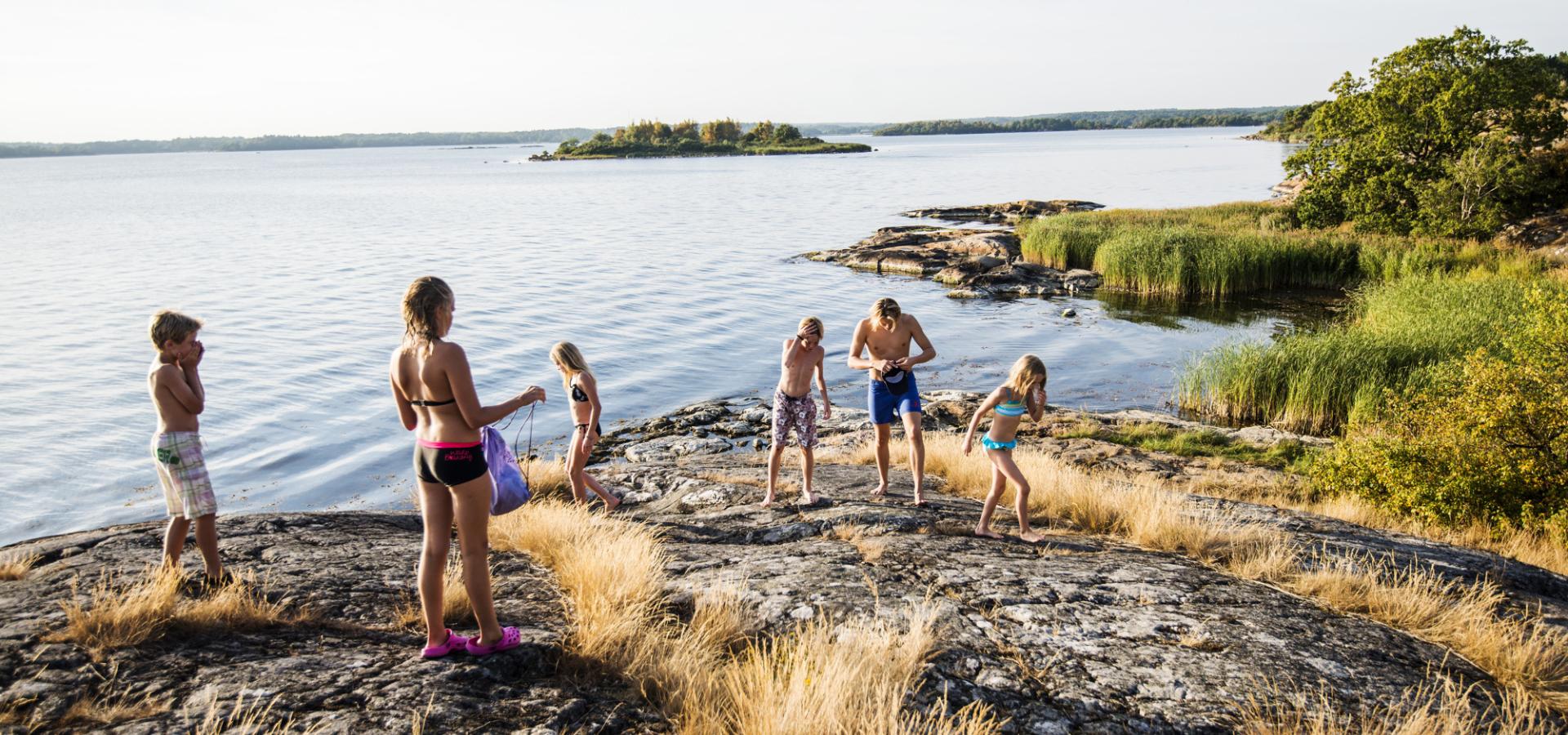 Barn som badar om sommaren i Karlskrona, i Blekinges skärgård.