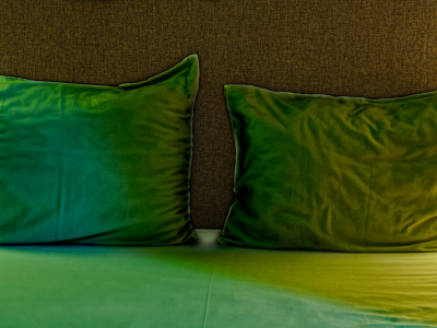 säng med gröna kuddar