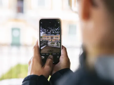 Man med mobiltelefon fotograferar.
