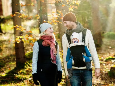 Familj som vandrar genom skog i Blekinge. Höstfärger.