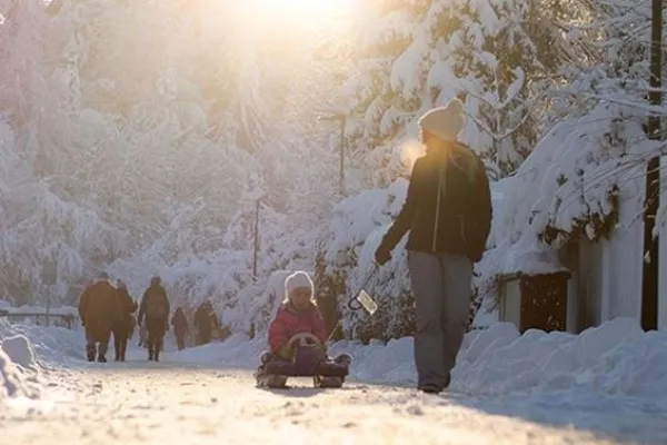 Kvinn drar barn i kälke