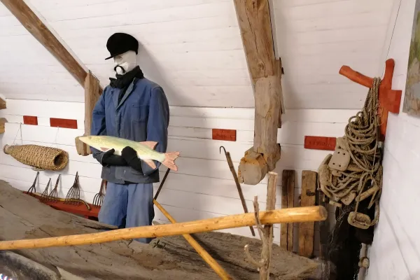 Människoskulptur som håller i en fisk