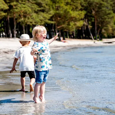 Barn som badar vid Hälleviks strandkant.