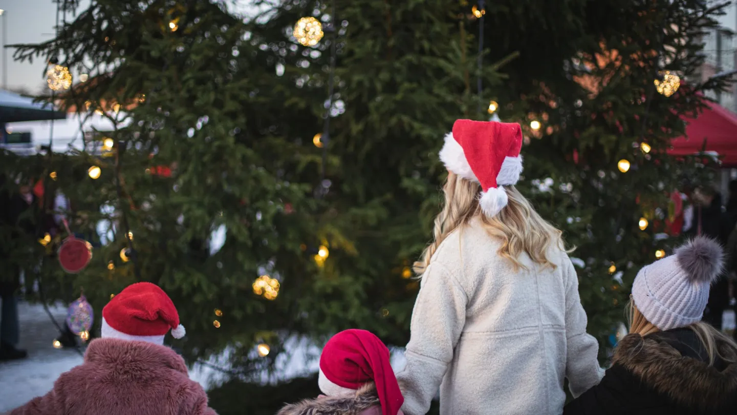 Barn och vuxna dansar runt granen under Julmys i Olofström